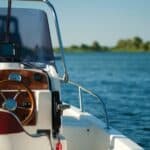 Boat in the water with steering wheel in foreground