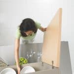 Woman opening cabinet door in the kitchen