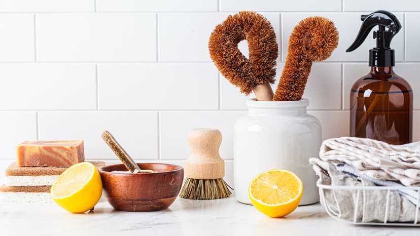 Sustainable cleaning supplies on kitchen counter with cut lemons and a bar of soap