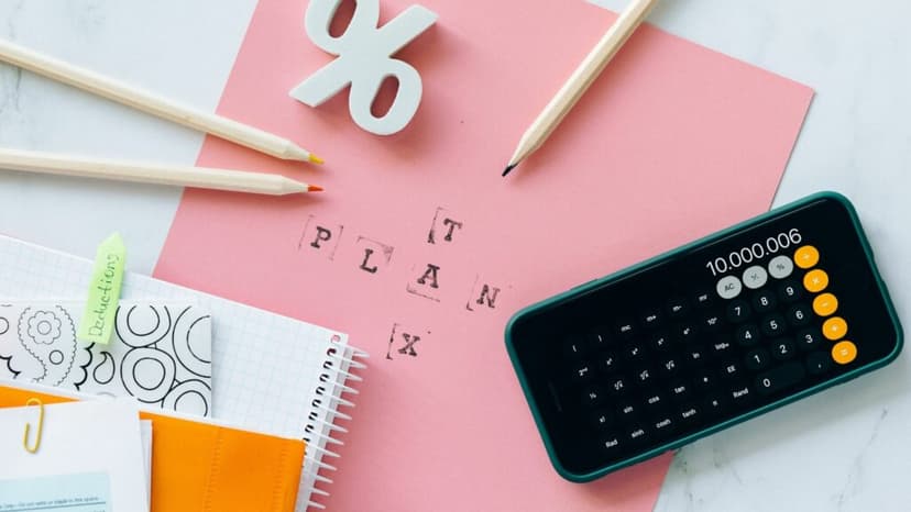 Calculator, pens, and notebooks laid out on a table