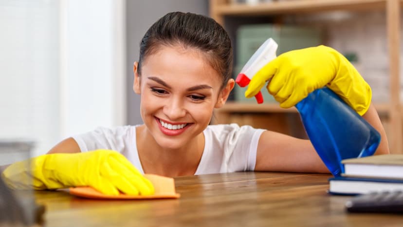 Airbnb cleaner using a spray bottle to sanitize counter