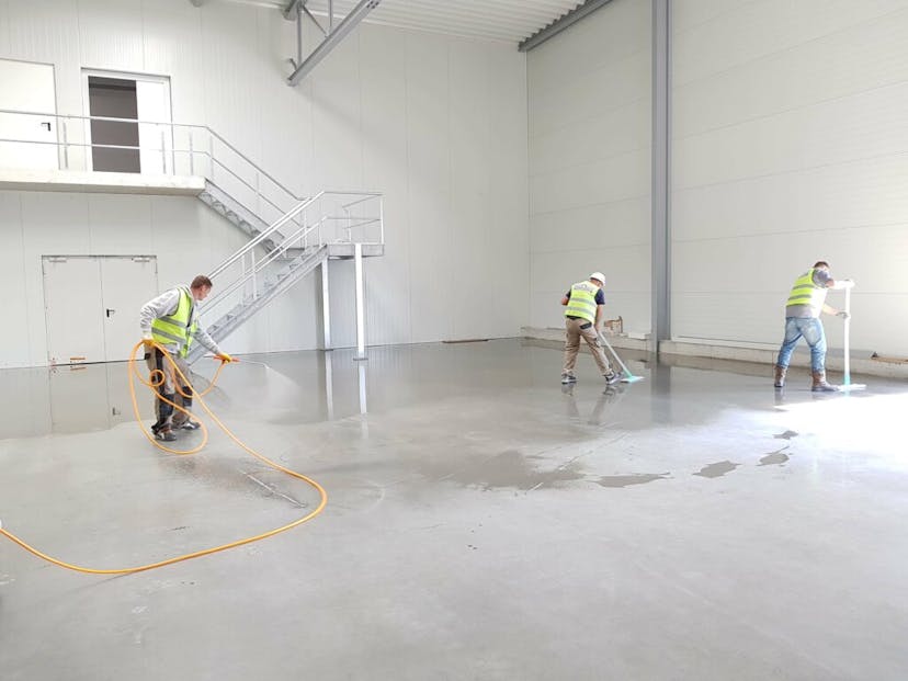 Construction cleanup crew in an empty warehouse