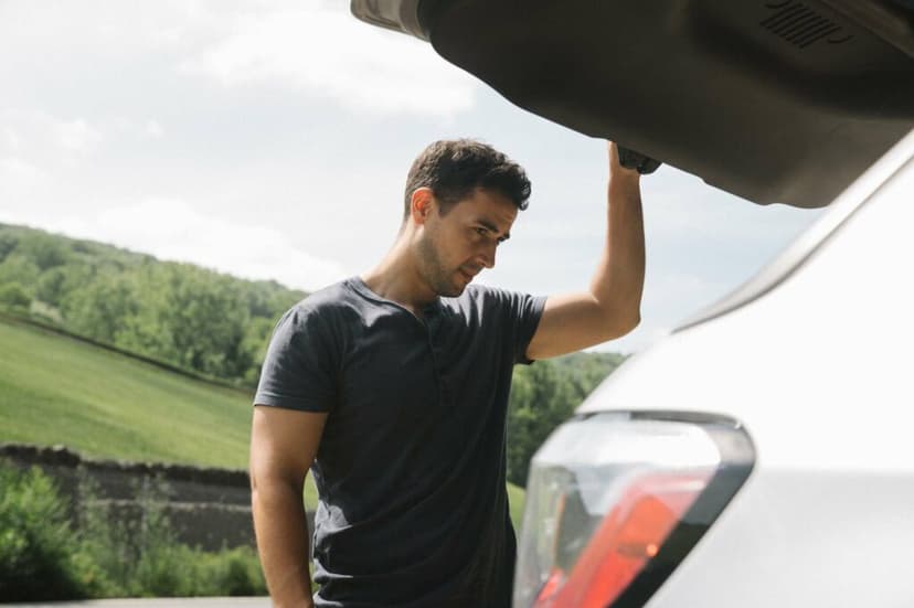 Man looking in the trunk of his car with the hatchback open