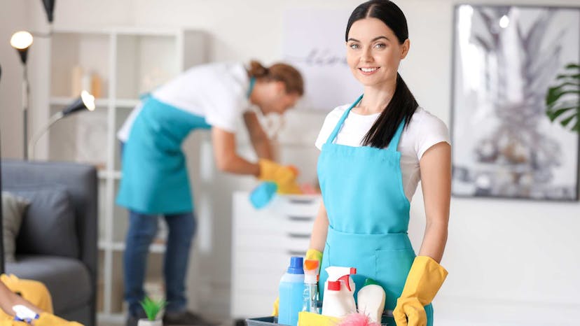 Residential cleaners sanitizing top surfaces and smiling