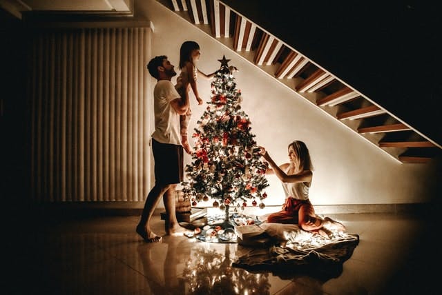 Family putting decorations on a Christmas tree